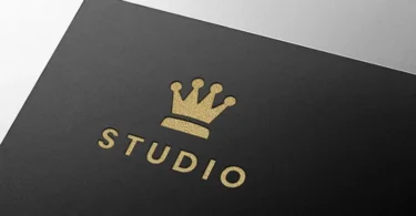 Premium luxury gold embossed logo mockup on black paper featuring a minimalist crown logo.
